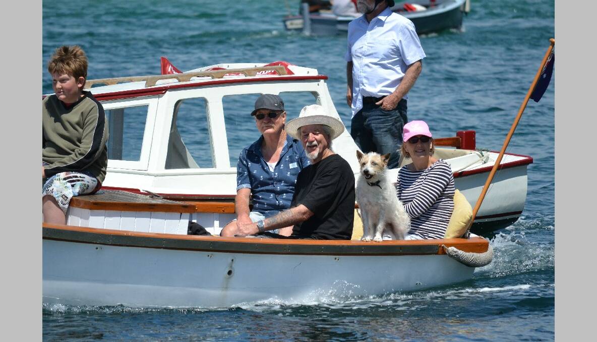 CHUGG AND TACK: As is tradition, Tack the dog enjoyed the parade with his master’s boat Chugg skippered by Tilba’s Stewart and Bev Long. 