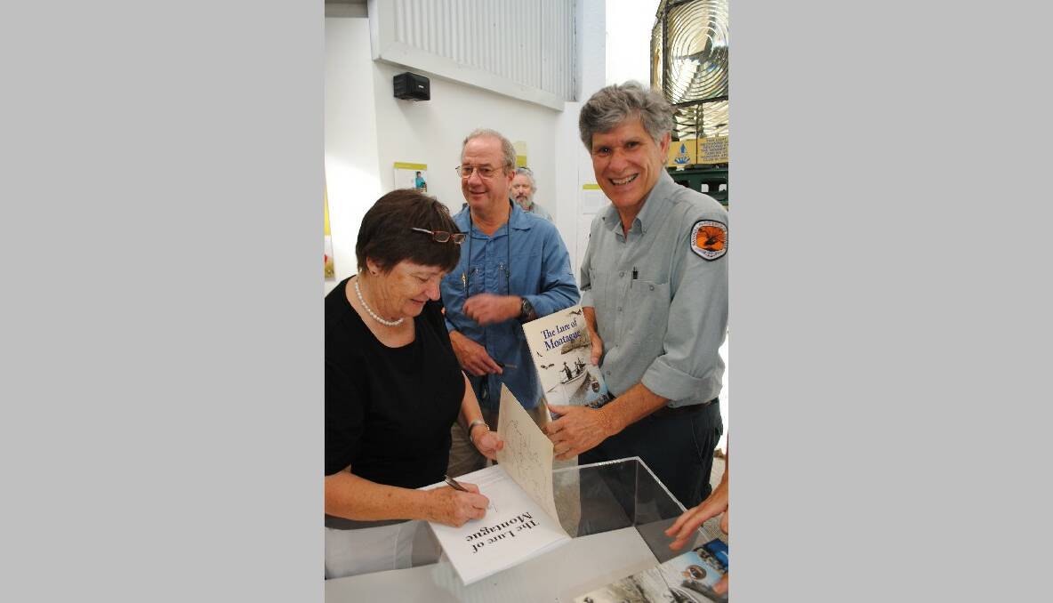 SIGNING: Laurelle Pacey signs a copy of her book The Lure of Montague for NPWS officer Preston Cope watched by NPWS Ross Constable. 
