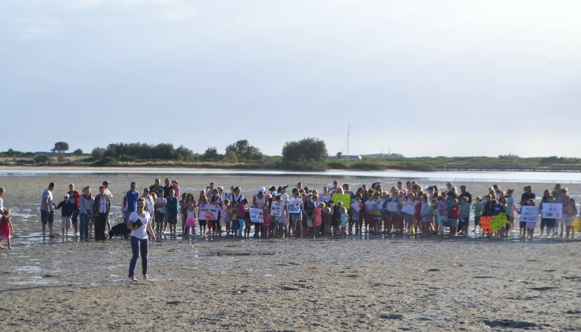 GROUP OUT: The crowd heads out on the sand flats of Wagonga Inlet to do another live cross to the studio.