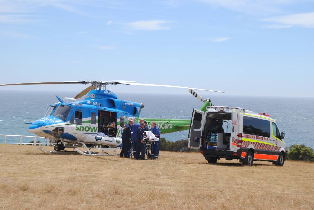 AIR LIFTED: The injured patient is delivered to the Snowy Hydro SouthCare rescue chopper on the Narooma headland to be airlifted to the Canberra Hospital. 