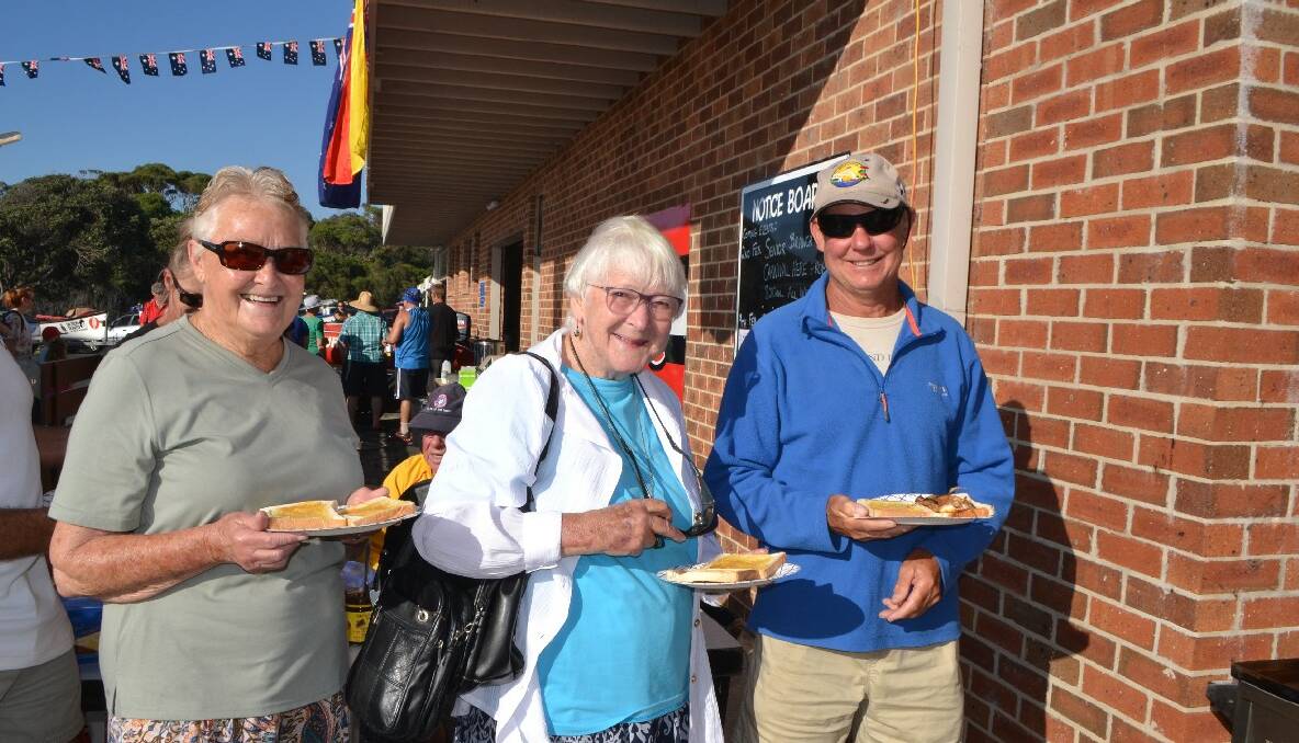 SNAG TIME: Margaret Littlewood and Patricia Andren from Dalmeny with Glenn Stevens from southern England waiting in line for snags at the Narooma Australia Day breakfast. 