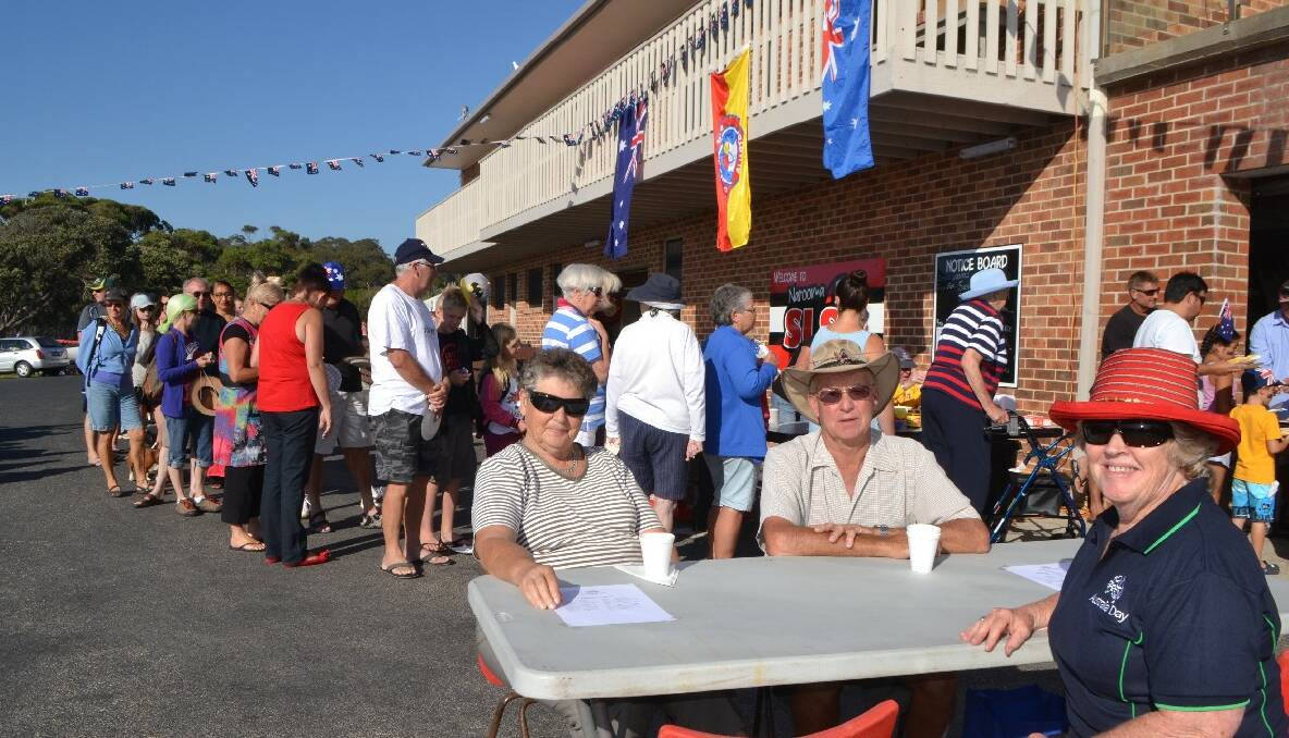 BREAKFAST LINE: Enjoying their Australia Day breakfast while the line builds in the background at the surf club are Narooma locals Marion and John Wisbey and Mandy Anderson. 