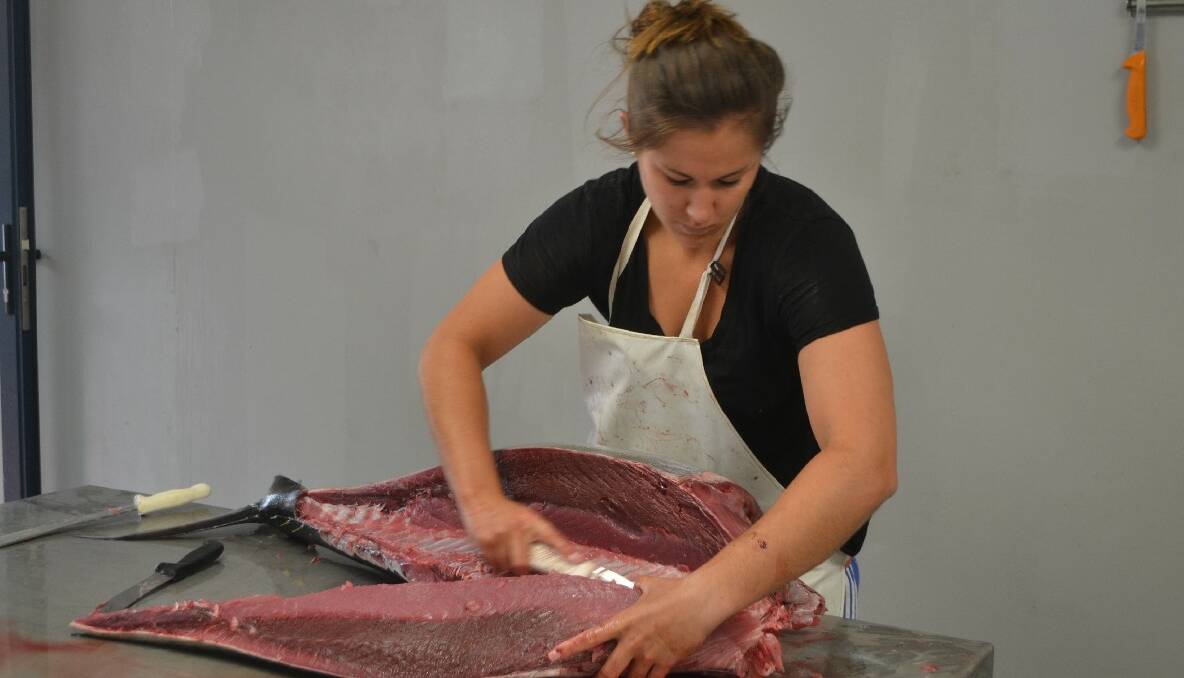 NEW FACTORY: The Abbott’s factory on Glasshouse Rocks Road has been transformed into a state-of-the-art fish processing plant and here Hayley butchers a yellowfin tuna. 