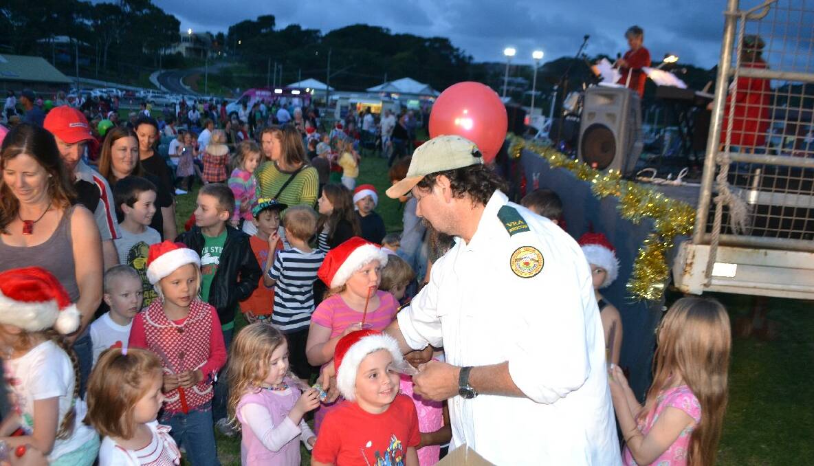 CAROL LOLLIES: VRA rescue squad member Jeff Garrad hands out lollies to the kids. 