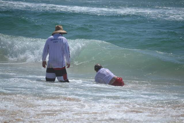 SURF ACTION: Far South Coast branch officials Paul White and Jimmy McGrath recover some lost equipment at the Far South Coast Life Saving Club senior carnival hosted by Narooma SLSC. Photo by Stan Gorton – Narooma News 