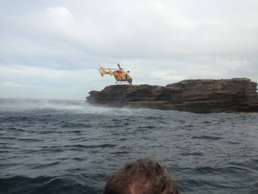 RESCUE CHOPPER: The Westpac Lifesaver 3 chopper hovers to retrieve the couple. Photo credit Batemans Bay SLSC