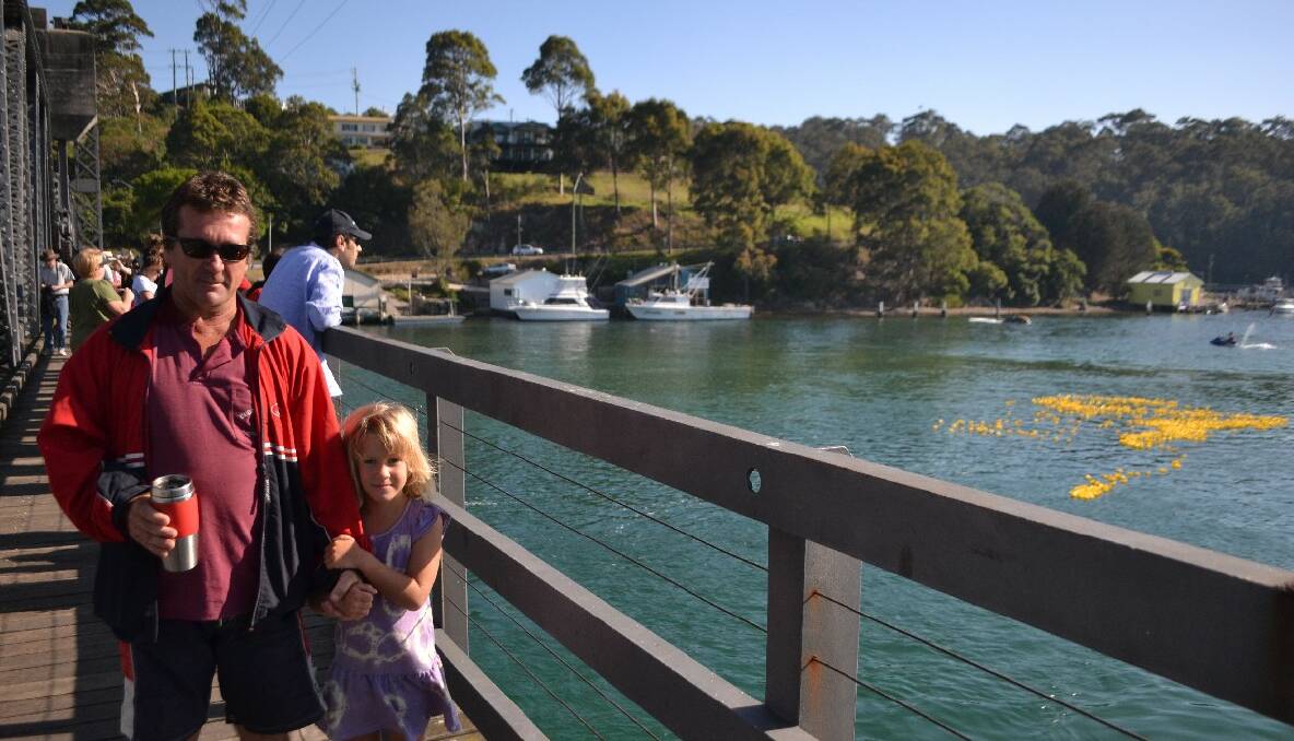 DUCK RACES: Narooma locals Graham Cannon and daughter Harmony see of the Rotary ducks as they are launched from the Narooma bridge. 