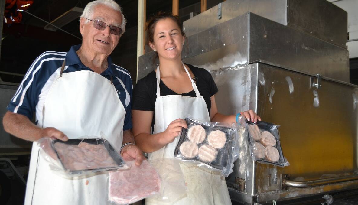 SEAFOOD DELIGHTS: Grandfather Des Creighton and Hayley Abbott with the packed tuna mince and fish cakes and the custom freezer trailer behind. 