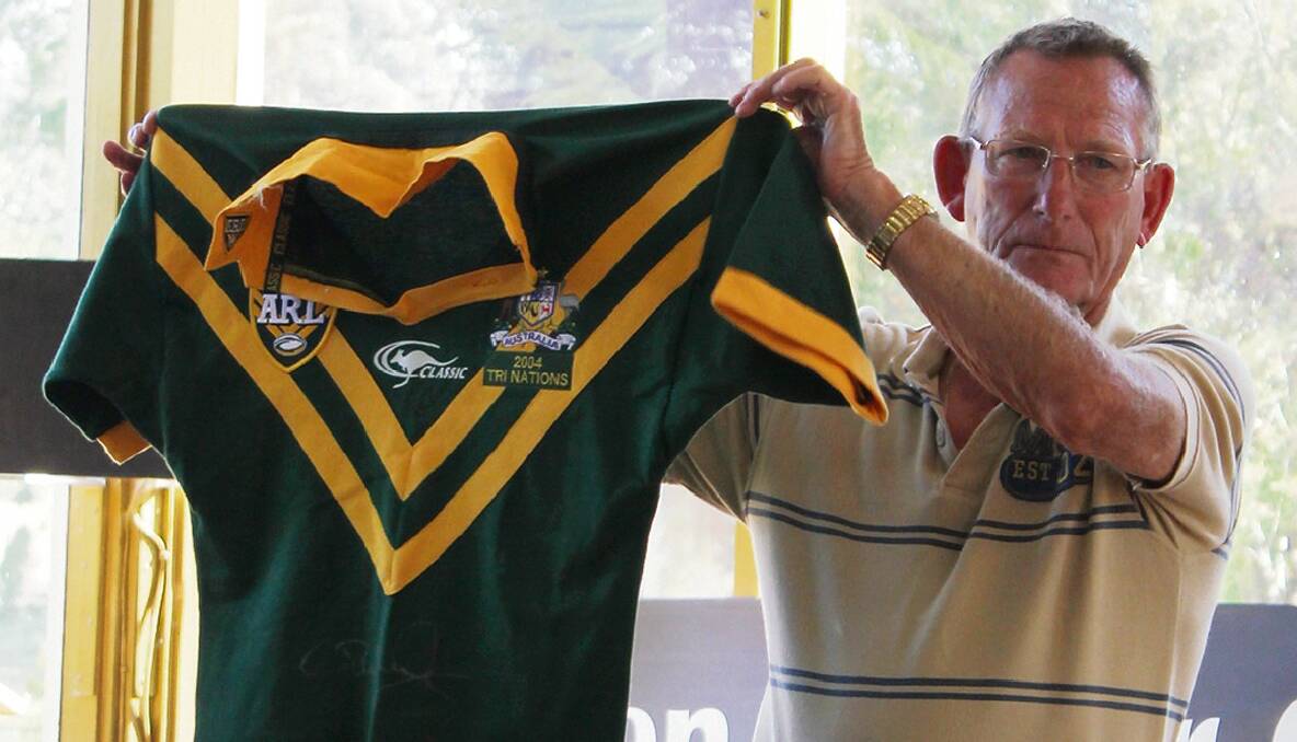 BEGA: Men of League charity golf day organiser Col Clarke shows off a tri-nations Australian jersey signed by Craig Wing during the auction.