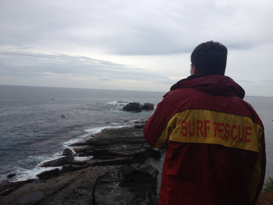 THE HEADLAND: A surf life saver surveys the scene from the headland at South Durras on Monday morning. 