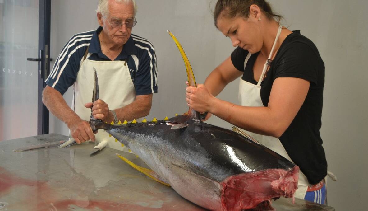 NEW FACTORY: The Abbott’s factory on Glasshouse Rocks Road has been transformed into a state-of-the-art fish processing plant and here Hayley butchers a yellowfin tuna with the assistance of pop Des Creighton. 