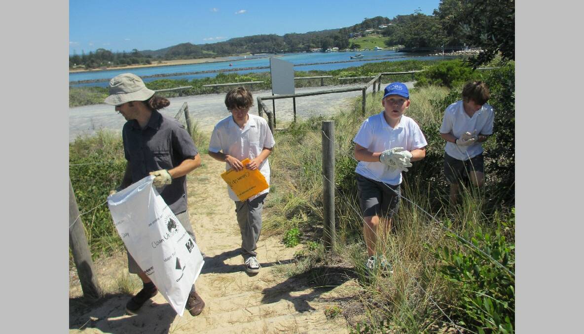 PICKING UP: Narooma High School teacher Dan Efraemson with students Jake Saly, Ammon Beard and Campbell Allison clean up rubbish at Bar Beach.