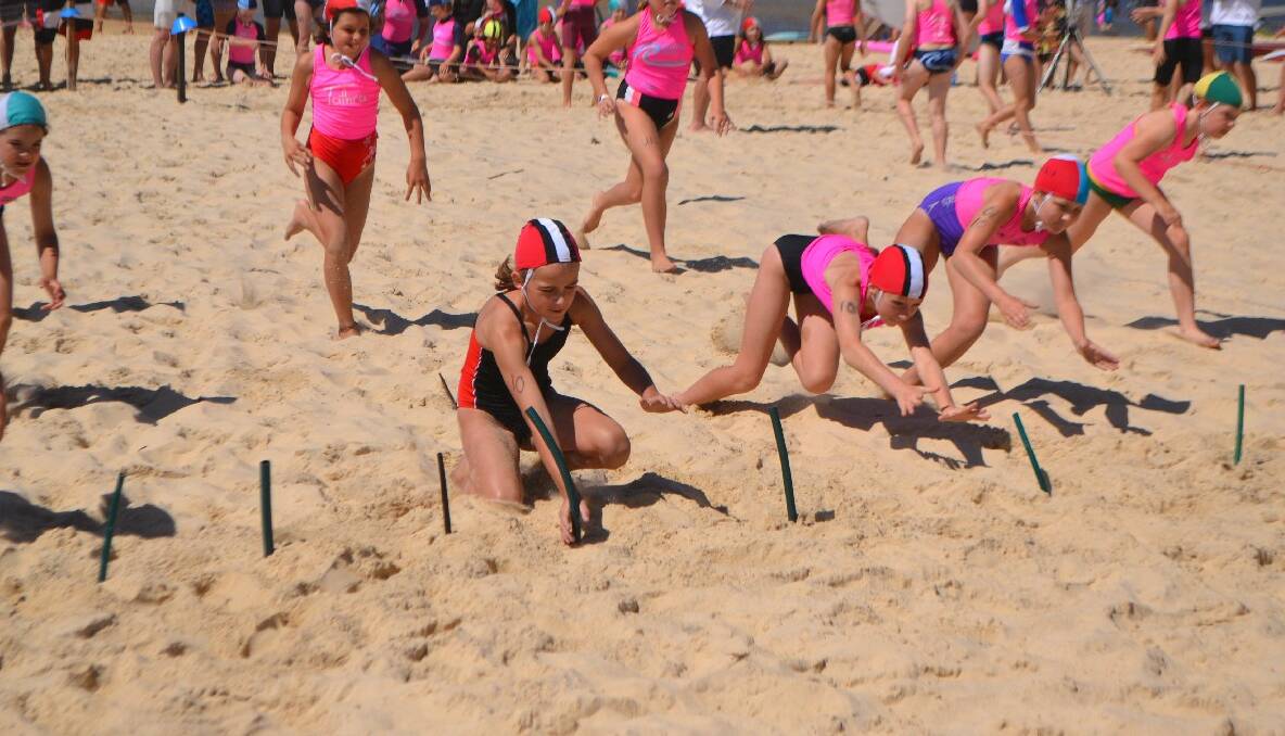 FLAG ACTION: Under 10 girls Elli Beecham and Hayley Stubbs diving for the flags ahead of Batemans Bay, Pambula and Tathra.