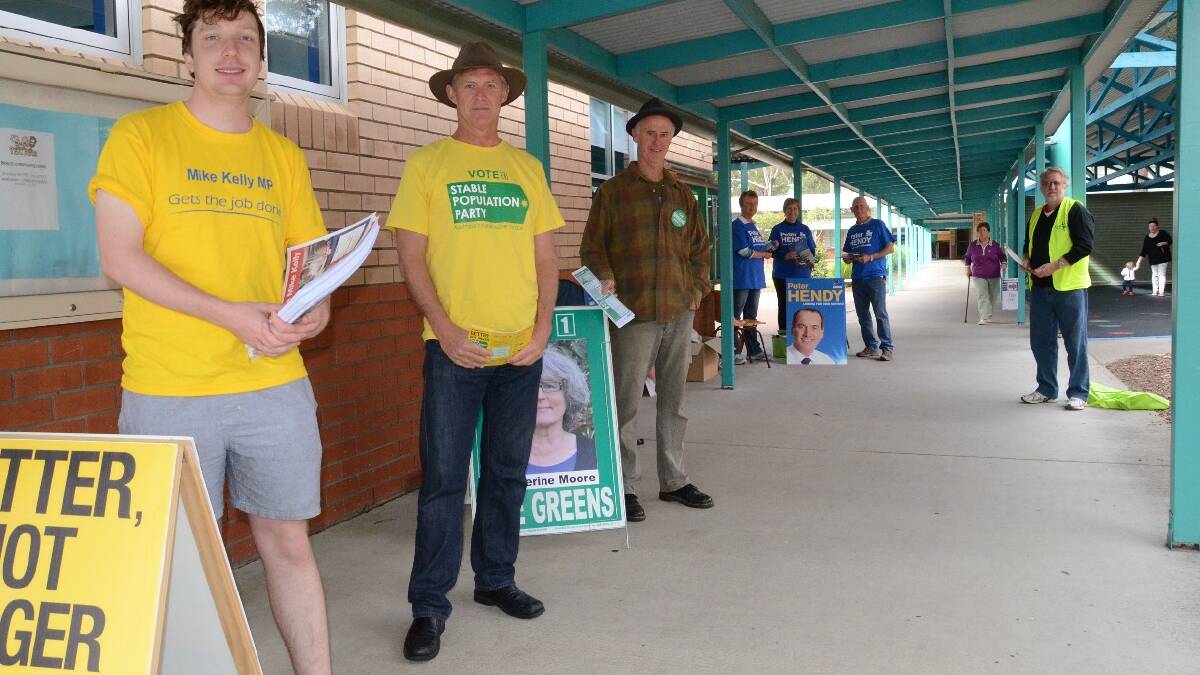 Party supporters hand out how to vote pamphlets at Broulee Public School early this morning.