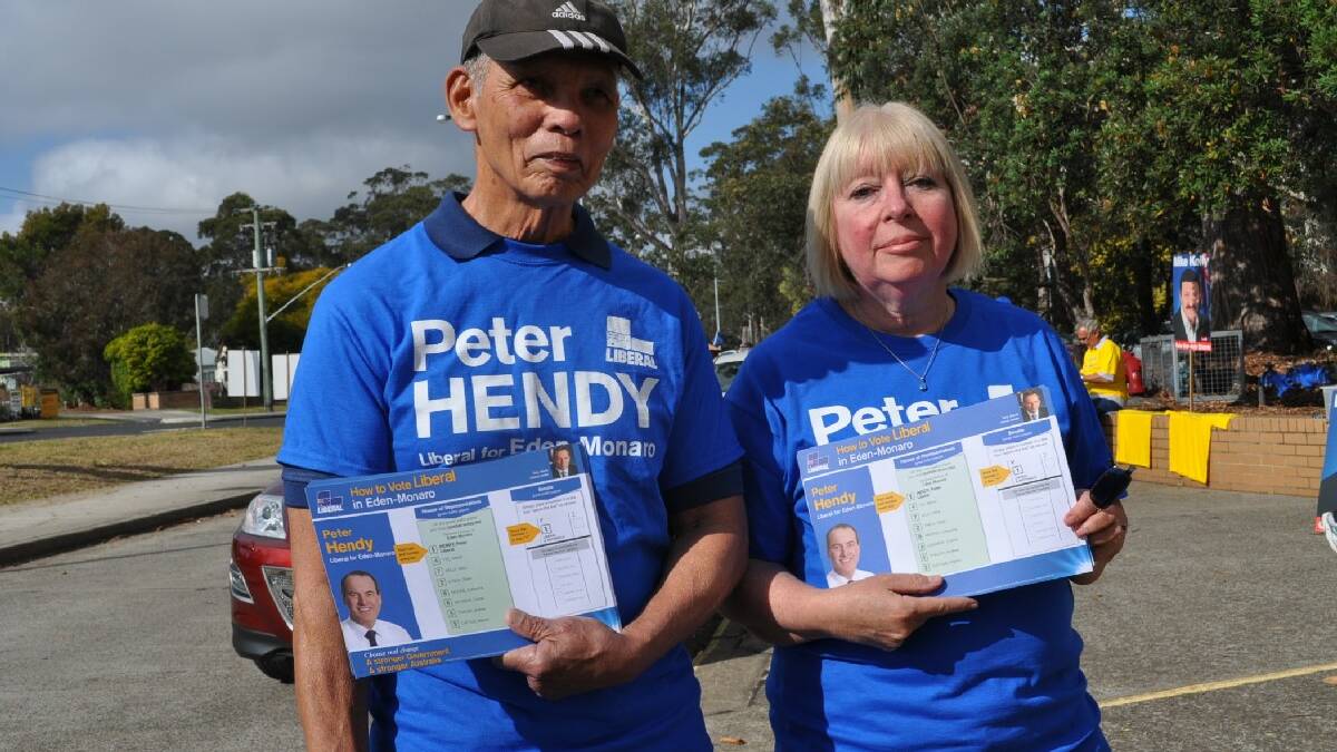 Jim and Elaine Hosie handing out how to vote cards at Batemans Bay High School. 