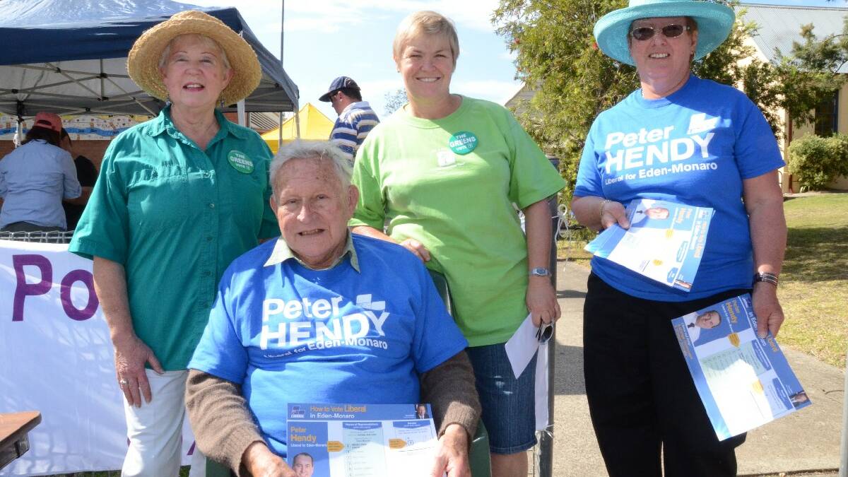Greens supporters Sharon Hendren and Jodie Quinnell, and Liberal supporters Nigel Neilson (seated) and Shirley Batho were handing out how to vote cards in Moruya.