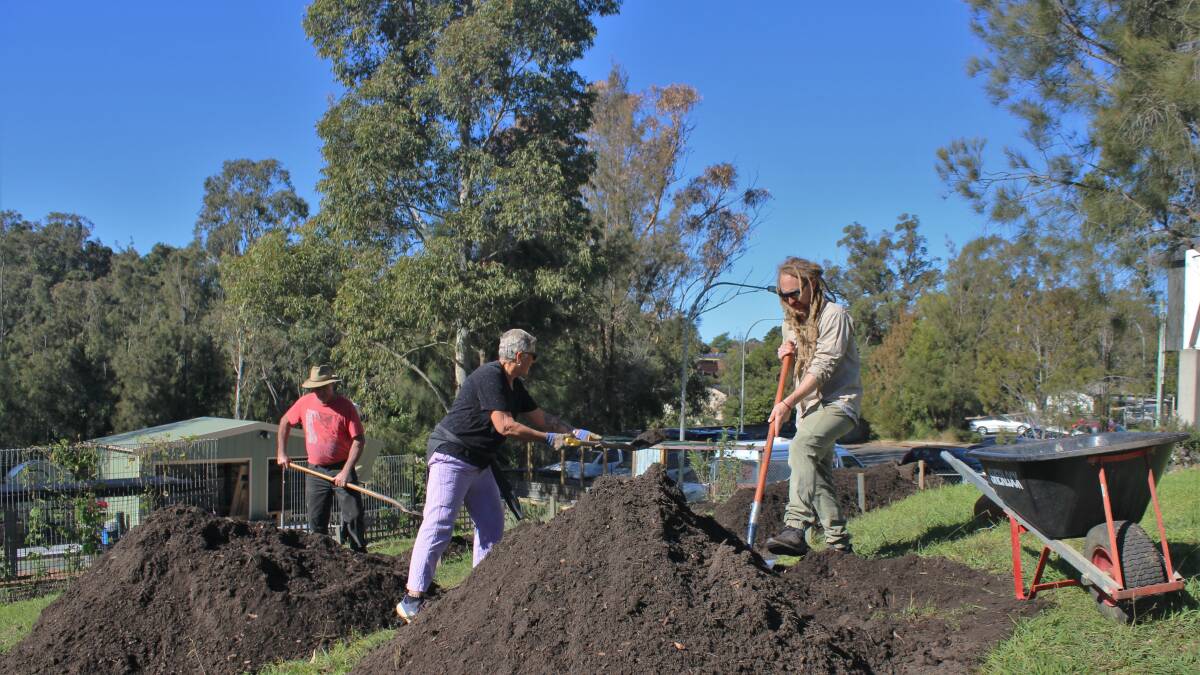 Salvation Army volunteers constructing new raised garden beds to grow vegetables.