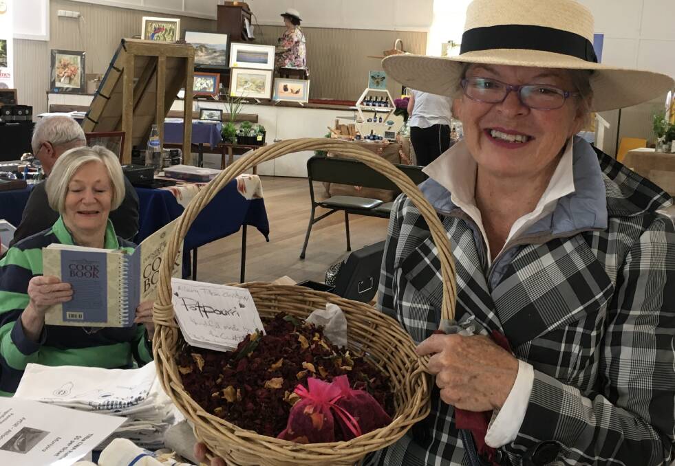 Tilba CWA members Zoe Bourke with her Tilba Rose potpourri and Irene Bynon reading a CWA Cookbook at the recent Veery Tilba Christmas market. Picture supplied