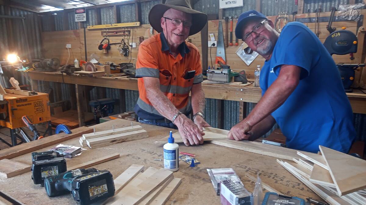 Some of the Frontier Services' Outback Links and NRMA volunteers building shelves for what will become the Cobargo Community Garden Room. Picture by Reverend Karen Paull