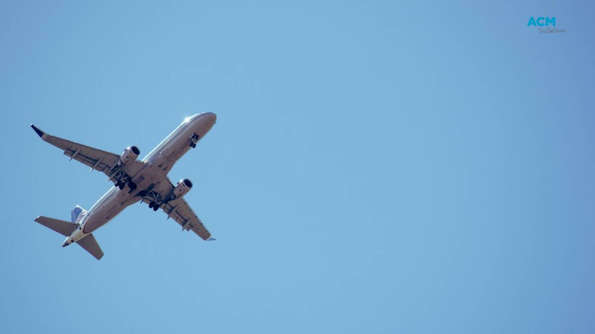 A plane flies overhead. Picture via Canva