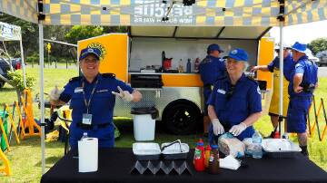 Volunteers enthusiastically cooking up snags at a Saturday morning fundraiser. Photo supplied.