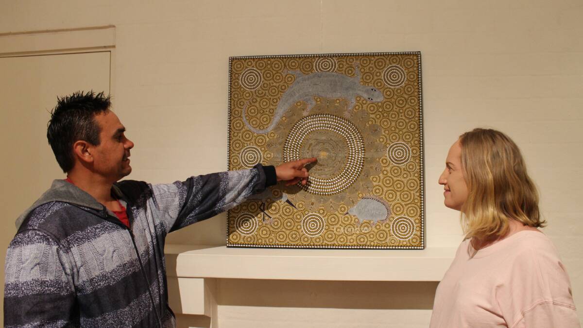 Lee Cruse shows wife Linda finer points of his painting Mirriah is All Around.
