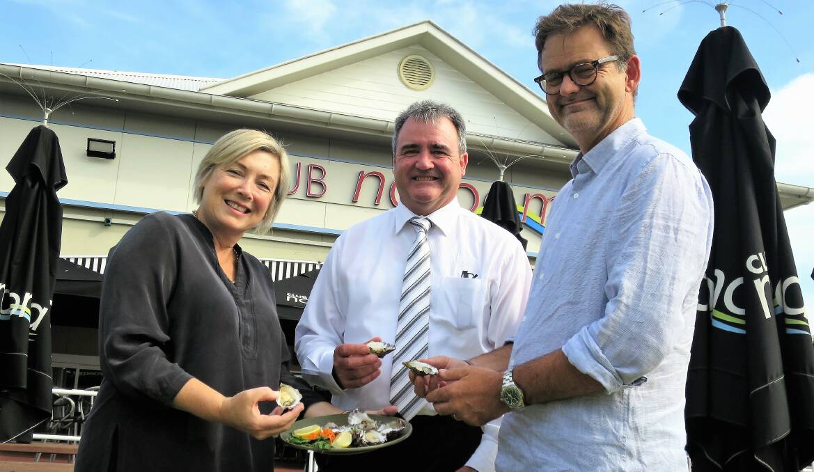 Narooma Sporting and Services Club CEO Tony Casu, centre, and Narooma Oyster Festival committee’s Cath Peachey and Niels Bendixsen, enjoy some oysters after Mr Casu gave them $15,500 in sponsorship.