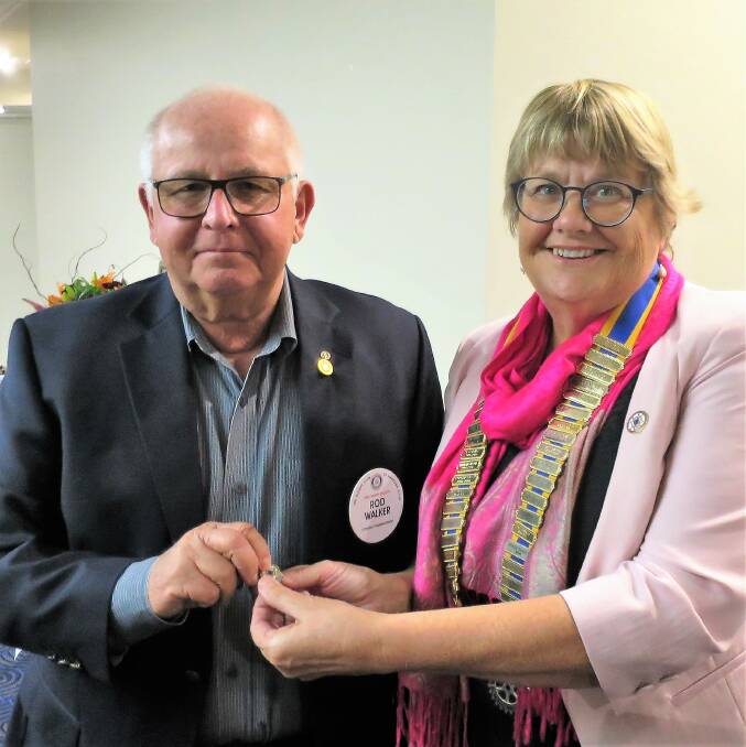 CHANGE: Outgoing Narooma Rotary president Rod Walker received a past president's pin from new president Charmaine White.