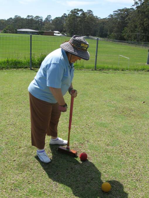Club Captain Christine Stent ponders a shot with the red ball onto the yellow ball to earn two extra shots in game 4 of ricochet croquet.