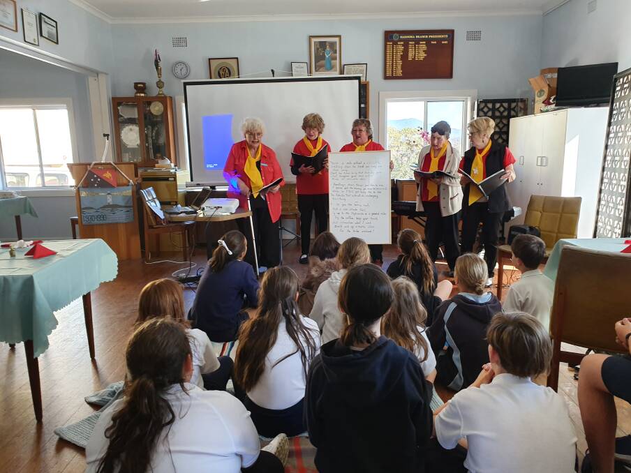 The small CWA choir taking part in recent International (PNG) afternoon with students from Narooma Public School.