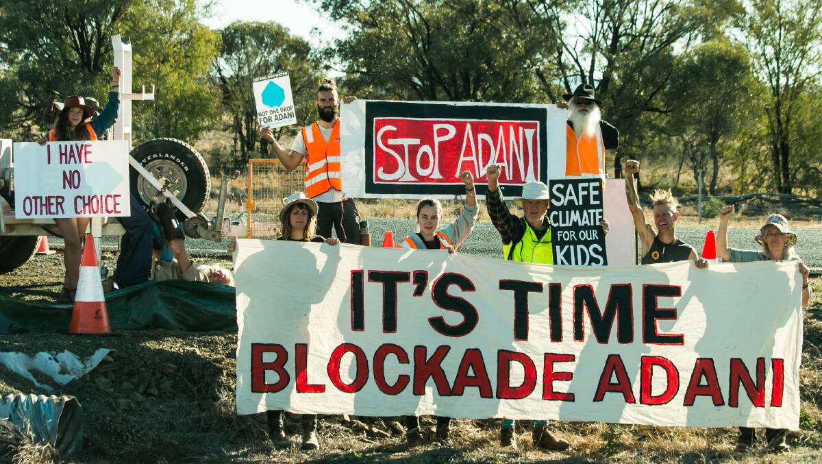 Anti-coal activists stand in front of Will Douglas at an Adani rail corridor in Queensland. 