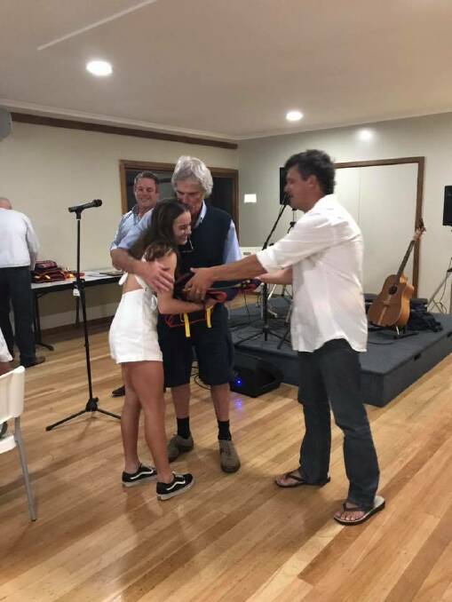 Elli Beecham receives the junior female life saver award from grandfather and surf club life member Chris Young and Brendan Constable. 