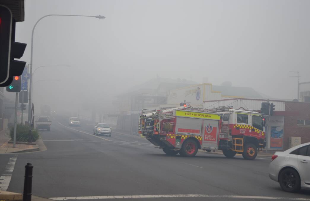 Narooma Fire and Rescue passes through the smoky intersection at Moruya. 