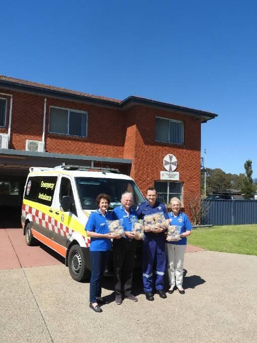 Anne Morrison, Michael Morrison, Paramedic Craig Potts, Margaret Latimer distributing Lions Trauma Bears.