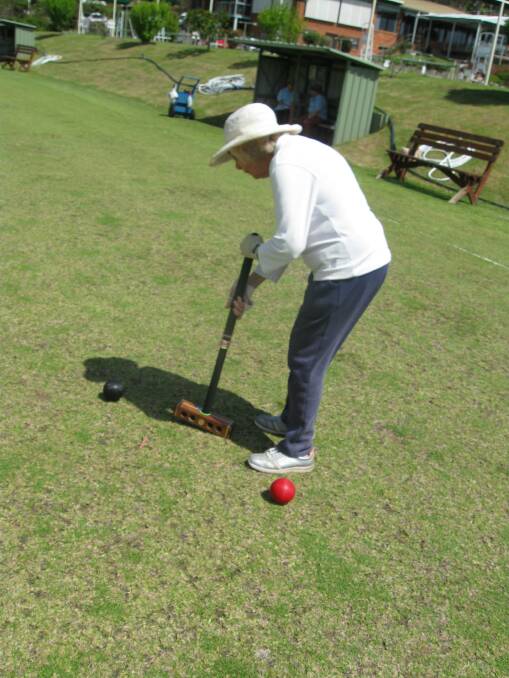 Sally McGourty scores with the red ball in game 3 of Thursday's golf croquet