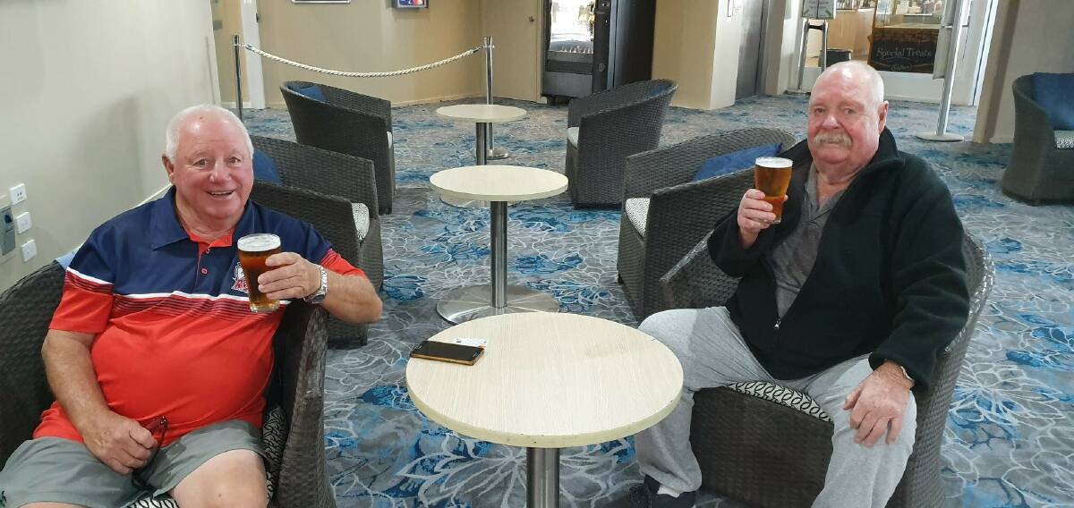 Golden goodness: Peter Bashford and Norm Wain enjoy their first draught beer back at the Narooma Golf Club on Friday. Picture: Narooma Golf Club.