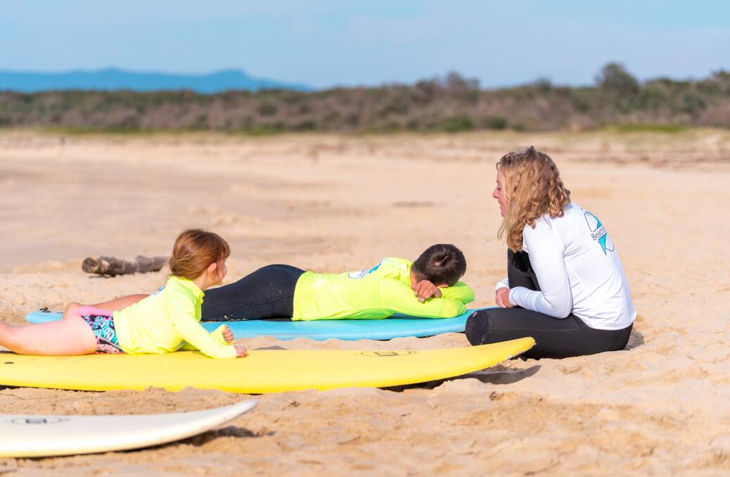 A nice change away from a clinic setting, Gabbie Johnson teaches clients how to surf.
