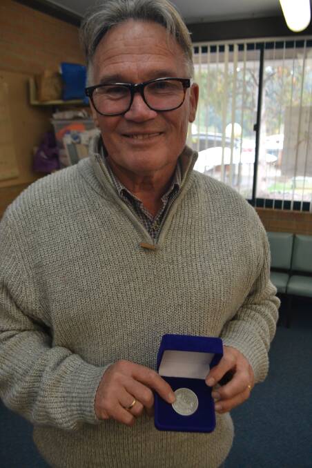 John Melville recieves a retirement medal for his dedication to Narooma High School.