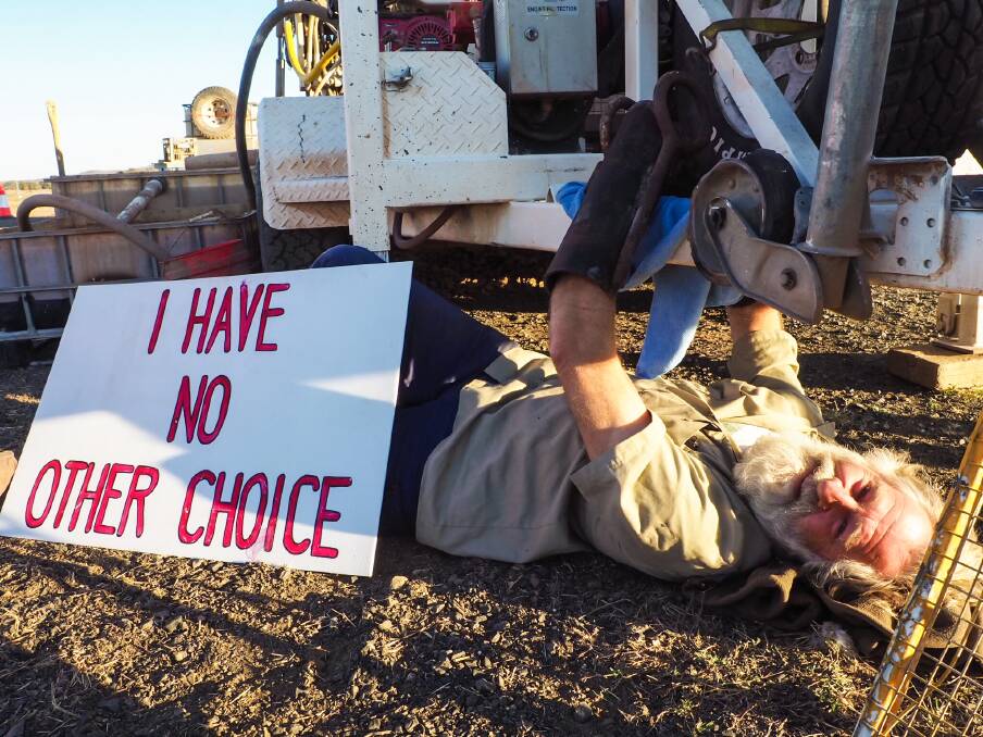 'NO CHOICE': Will Douglas locks on to machinery as he protests in Queensland on Wednesday. Image: Frontline Action on Coal.