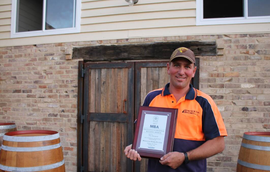 Bermagui builder Brad Muncktonwith his Master Builders Association award for his renovation of Camel Rock Brewery and Cafe. Picture: Alana Beitz