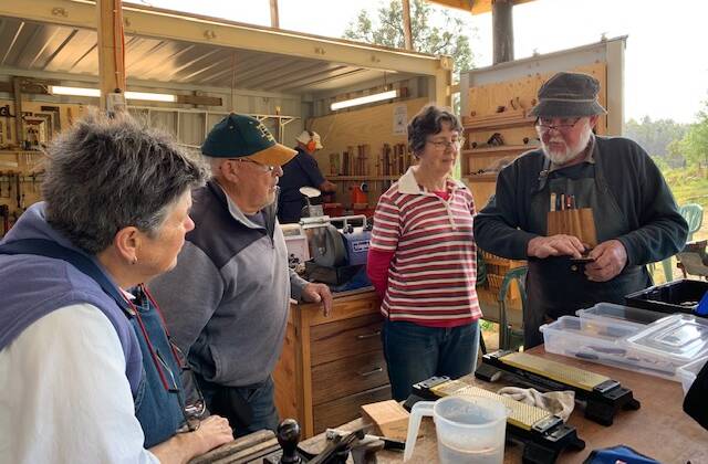 Woodworkers discussing how to transform timber chunks into works of art at the Tilba Woodwork exhibition.