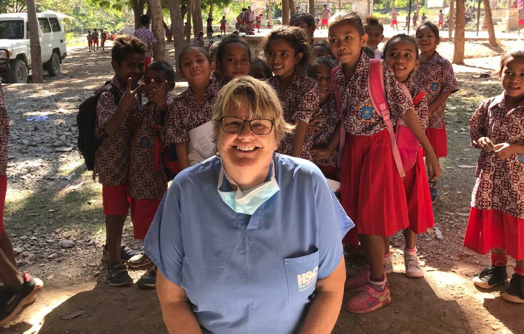 OPEN WIDE: Narooma's Charmaine White with children from the Bogoro School, Timor Leste. Dr White's dental team filled 406 teeth and extracted 527 others during the two weeks project. 