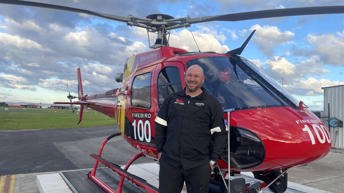 Pilot Adam Cassin pictured with the helicopter he spent so much time in during Blacvk summer. Picture supplied