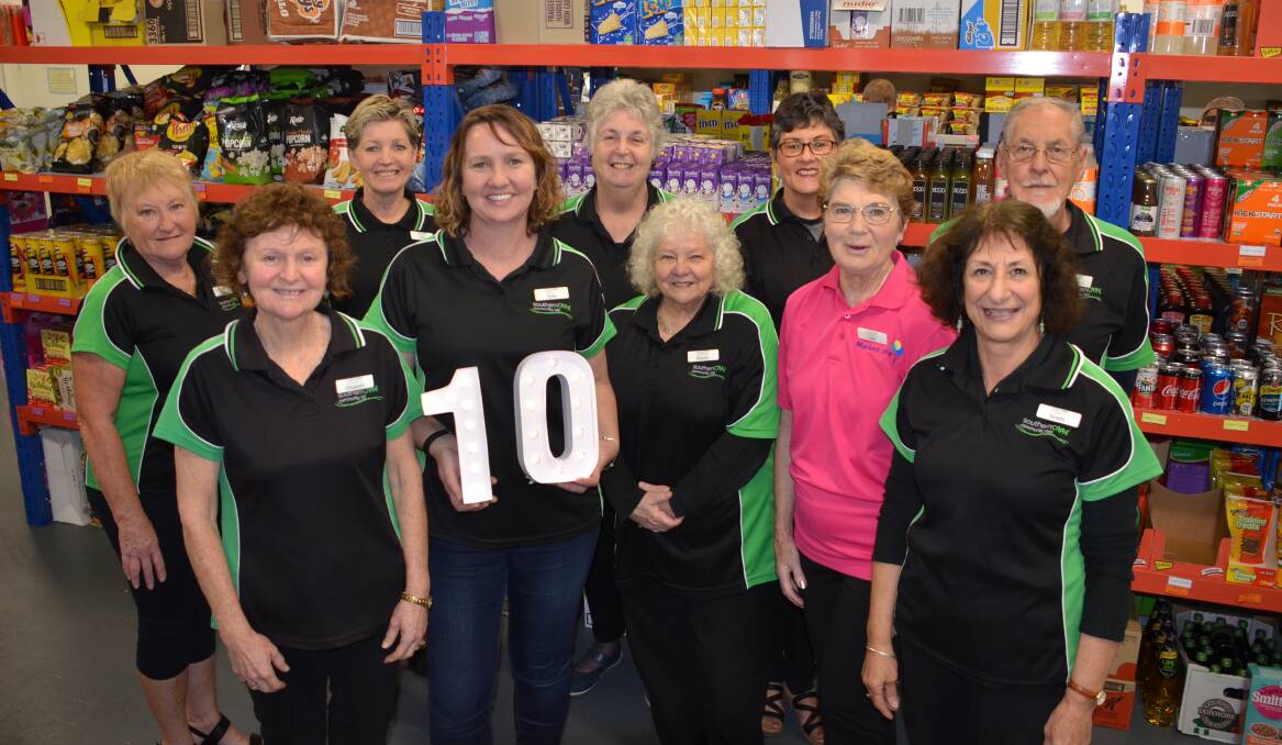 HERE TO HELP: Moruya Pantry Club's Kylie Cursio-Young (holding 10) and team celebrate a decade of service, but know times just get harder.