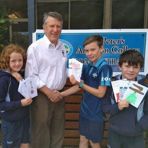 SEASON OF GIVING: Junior school students at St Peter's Anglican College in Broulee gift handmade Christmas cards to Eurobodalla Meals on Wheels' Alan Russell, to pass on to clients.