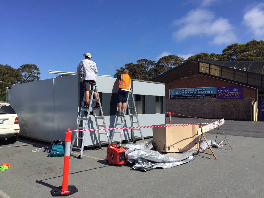 NEW MACHINE: Workers install the new machine at the Narooma Plaza last week.