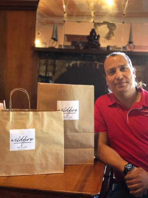 Waste not, want not: Rosh Shrestha of Narooma's Wildfire Restaurant with doggy bags of uneaten food for customers to take home.