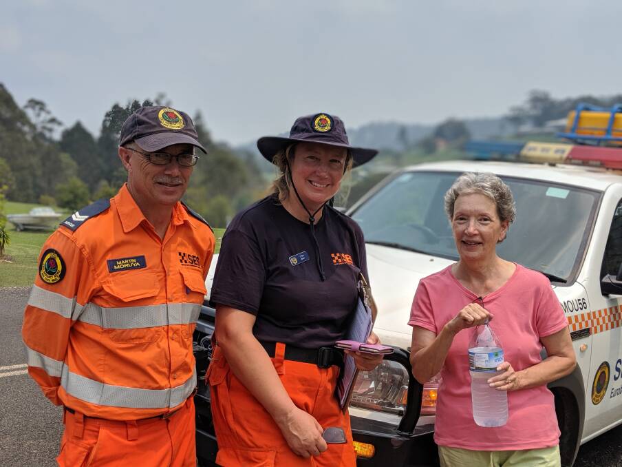 GRATEFUL: A Narooma resident offers Moruya SES volunteers Martin Ransom and Lydia Ronnenkamp water on Wednesday, January 29.