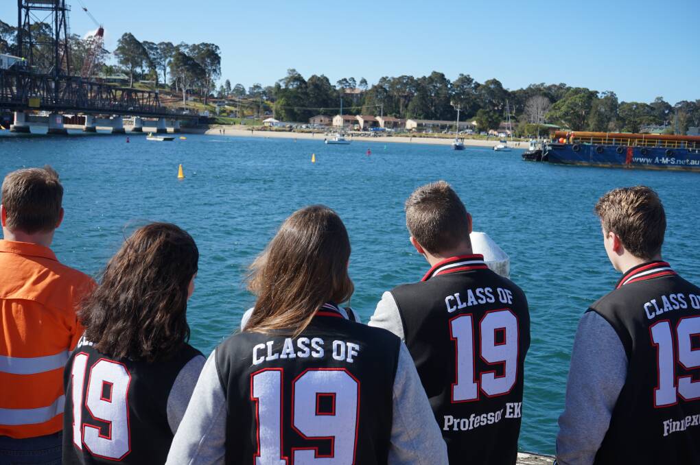 Year 12 students watch as the barge prepares to travel under the bridge.