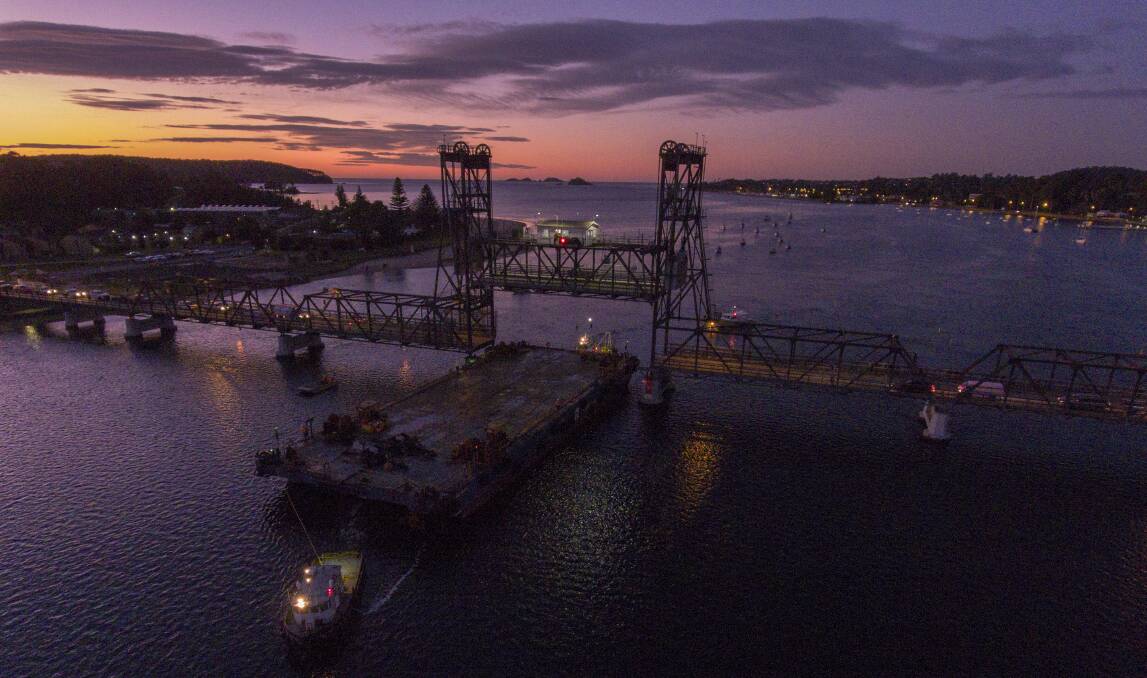 Two local tug boat operators steer the barge through the lift span in Batemans Bay on July 12.